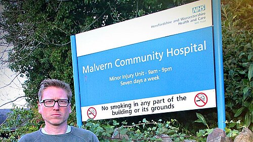 Dan Boatright-Greene standing in front of Malvern Community Hospital